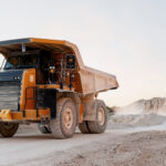 Mining truck covered with dust, working in an open excavation area