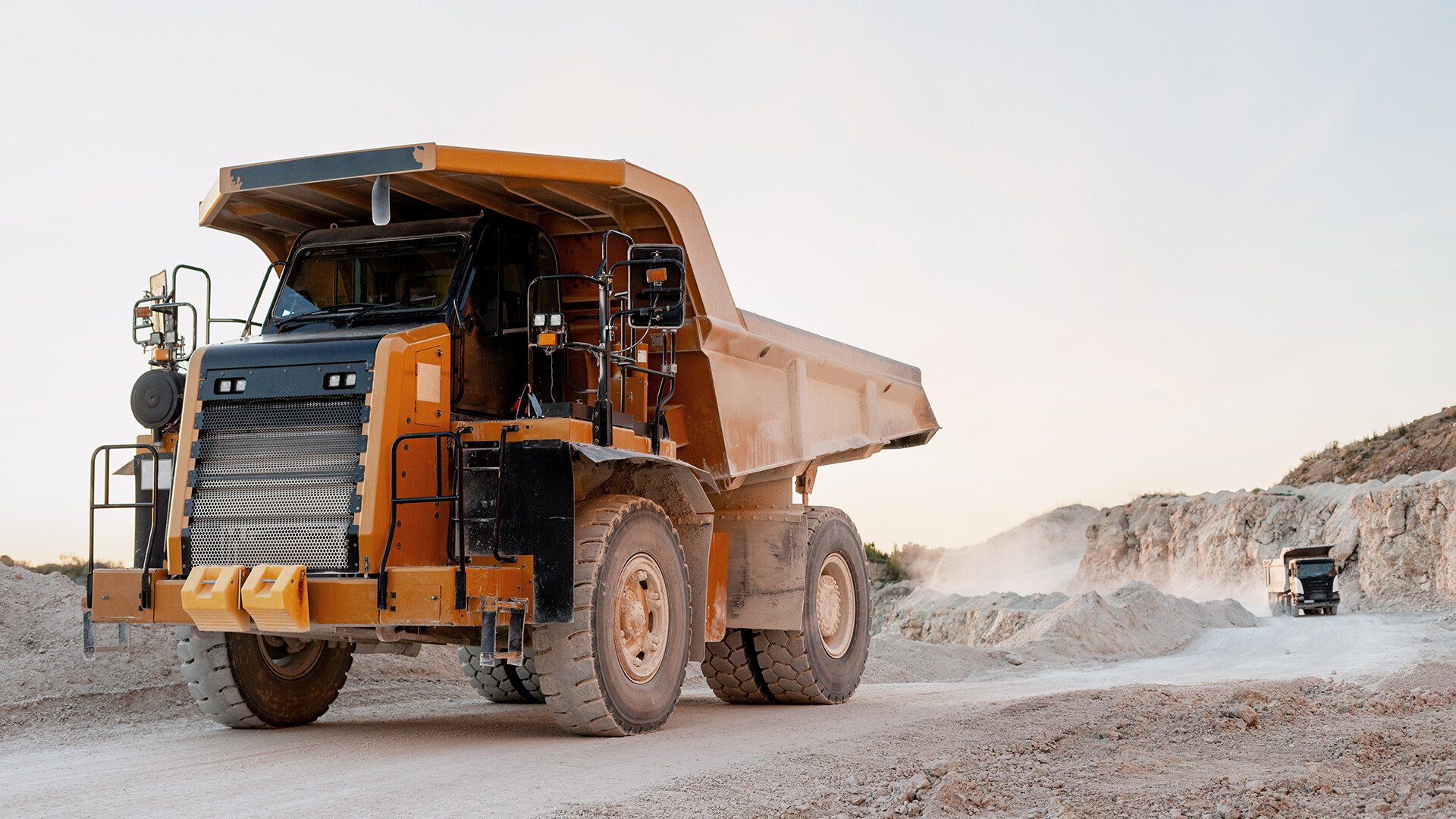 Mining truck covered with dust, working in an open excavation area